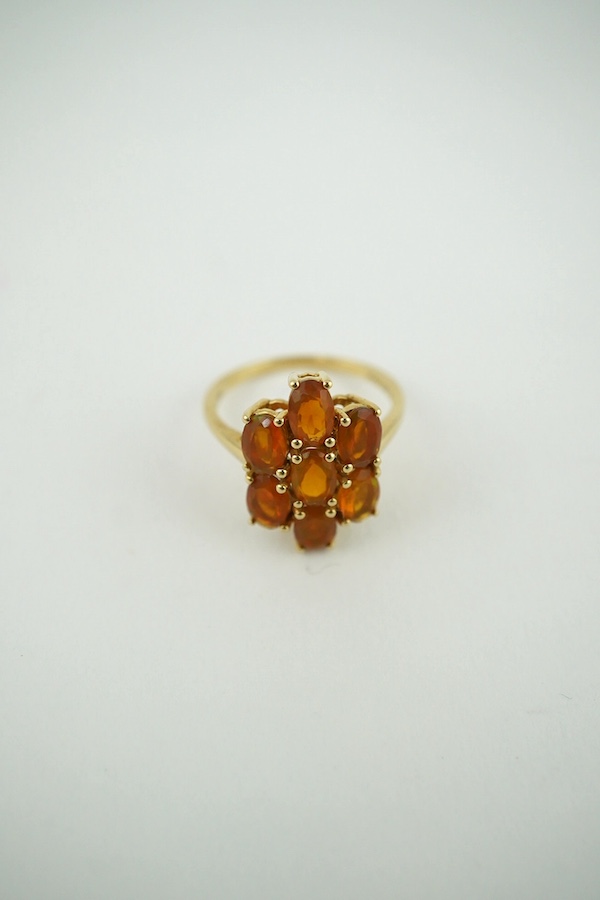 A 10K yellow gold orange stone cluster dress ring, size N, gross weight 2.6 grams. Condition - fair